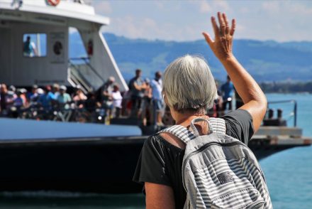 A woman waving at people on a boat representing some of the most popular American tourist destinations for seniors
